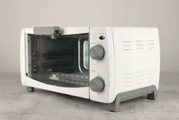 The front of a closed white Comfee CFO-BB101 Compact Toaster Oven has a control panel and the right side has holes.