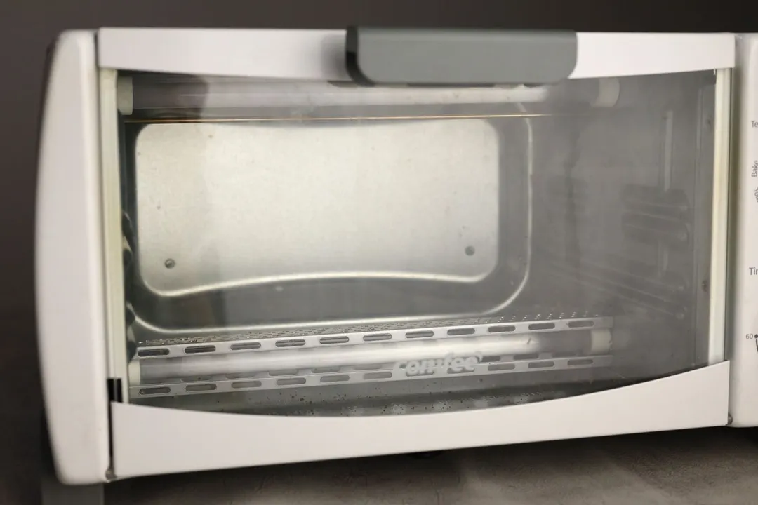 Grease on the glass door of a closed white Comfee CFO-BB101 Compact Countertop Toaster Oven.