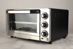 The front of a closed Cuisinart TOB-40N Custom Classic Toaster Oven Broiler has a control panel and the right has holes.