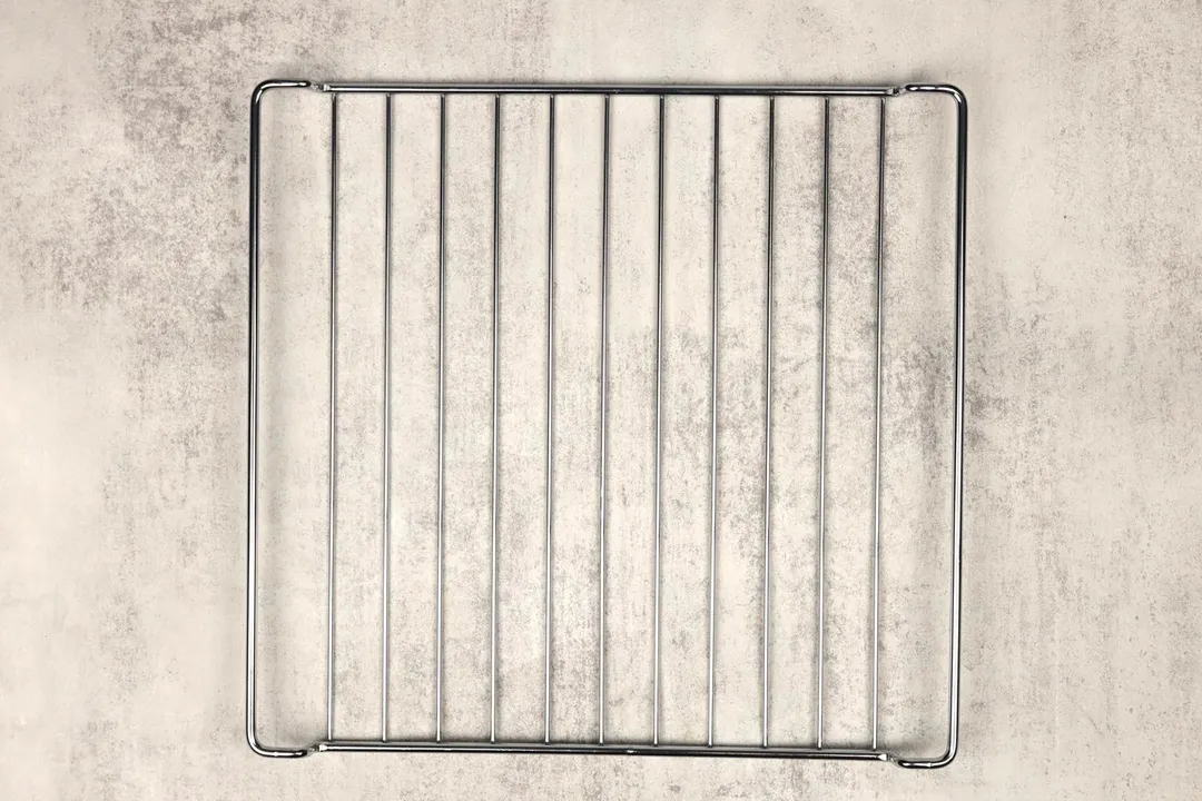 A stainless steel baking rack of the Cuisinart TOB-40N Custom Classic Toaster Oven Broiler on a grey background.