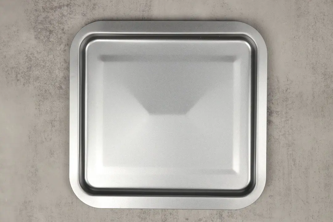 A silver baking pan of the stainless steel Cuisinart TOB-40N Custom Classic Toaster Oven Broiler on a grey background.