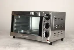 The front of a closed Hamilton Beach 31401 4-Slice Countertop Toaster Oven has a control panel and the right has holes.