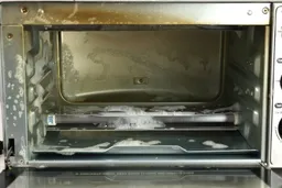 Washing the cooking chamber of the stainless steel Hamilton Beach 31401 4-Slice Countertop Toaster Oven with dish soap.