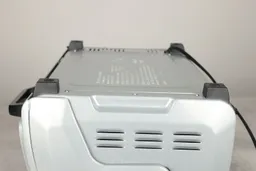 On a grey background, the bottom of the Hamilton Beach 31127D 6-Slice Easy Reach Toaster Oven has four stands and holes.