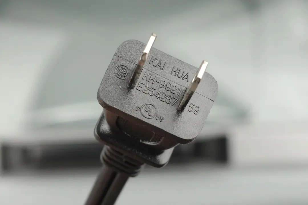A two-pronged plug power cord. In the background is the Hamilton Beach 31127D 6-Slice Easy Reach Roll Top Door Toaster Oven.