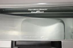 Grease on the glass door of a closed stainless steel Hamilton Beach 31127D 6-Slice Easy Reach Roll Top Door Toaster Oven.