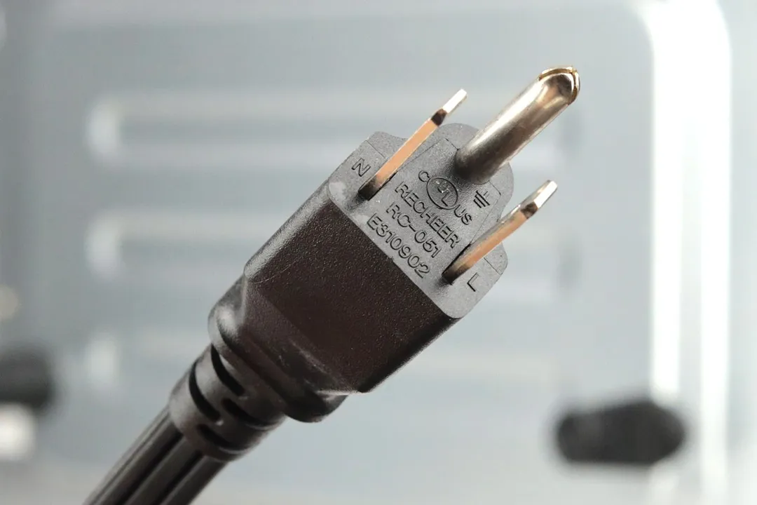 A three-pronged plug power cord. In the background is the Toshiba AC25CEW-BSConvection Toaster Oven.
