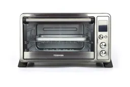 The front of a closed Toshiba AC25CEW-BS Convection Toaster Oven has a control panel and a glass door with a handle.