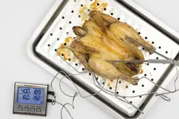 A tray of whole toaster oven roasted chicken. The thermometer has two probes inside the chicken and displays 189°F and 192°F.