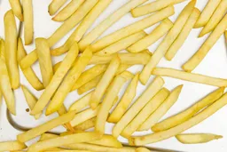 A close-up of pieces of baked french fries using a toaster oven on a silver baking pan.