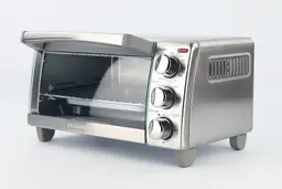 The front of a closed Black+Decker TO1760SS Natural Convection Toaster Oven has a control panel and the right has holes.