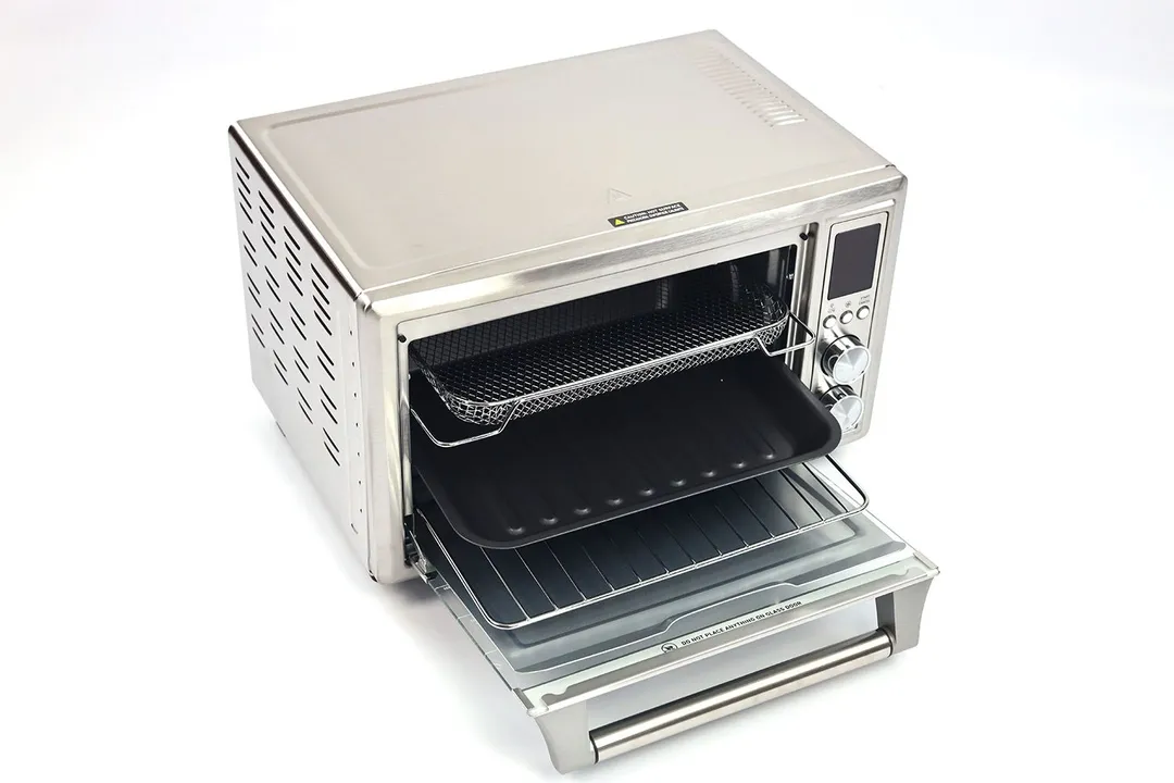 The front of an opened Cosori CO130-AO Toaster Oven with a removable crumb tray, oven rack, baking pan, and air fryer basket.