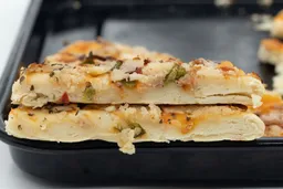 Two slices of oven baked 9-inch thick-crust meat pizza with cheese, onions, and green bell peppers on top of one another.