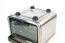 On a white background, the bottom of the Ninja DT201 Foodi XL Pro Air Toaster Oven has air ventilation holes and four stands.