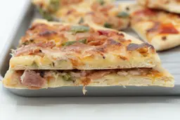 Two slices of oven baked 9-inch thick-crust meat pizza with cheese, onions, and green bell peppers on top of one another.