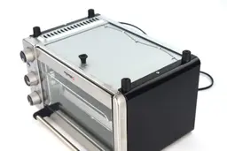 On a white background, the bottom of the Mueller MT-175 Toaster Oven has a detachable crumb tray, four stands, and holes.