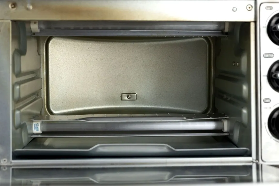 An open front of the Hamilton Beach 31401 Toaster Oven. On the right are three black control knobs. The interior has two tray levels and two heating elements with guards.