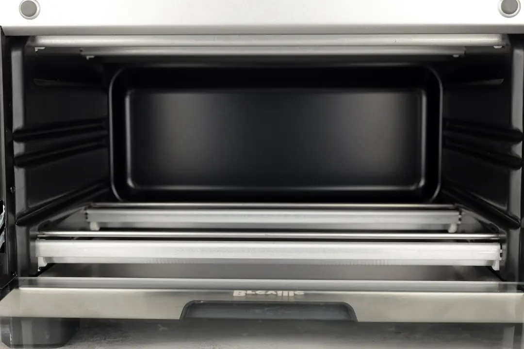 The Breville BOV450XL ’s cooking chamber is black and has 4 quartz heating elements with guards and 2 guide rails.