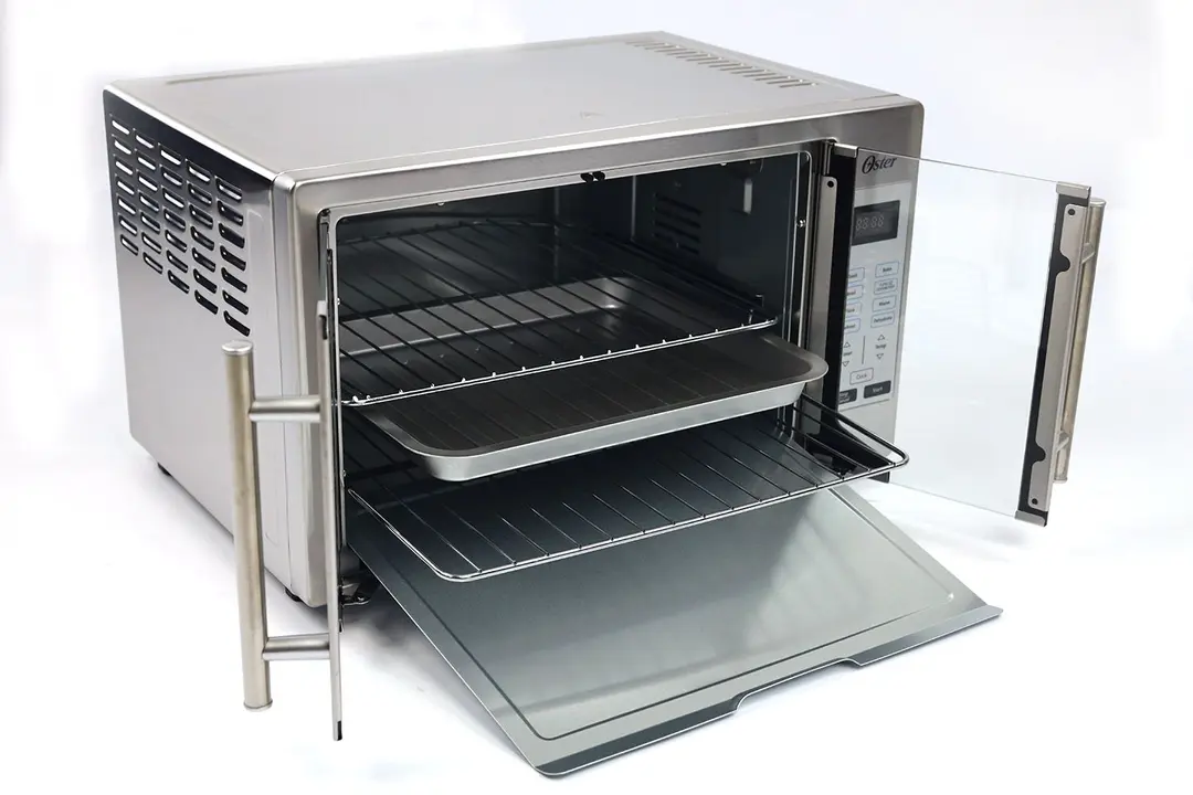 An opened Oster TSSTTVFDDG XL Digital French Door Toaster Oven on a white background. Inside the cooking chamber, from the bottom up are one removable crumb tray, one baking rack, and one baking pan under another baking rack.