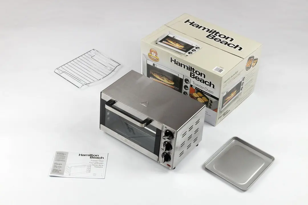 An oven rack, a user manual, the Hamilton Beach 31401 4-Slice Capacity Countertop Toaster Oven, a box, and a baking pan.