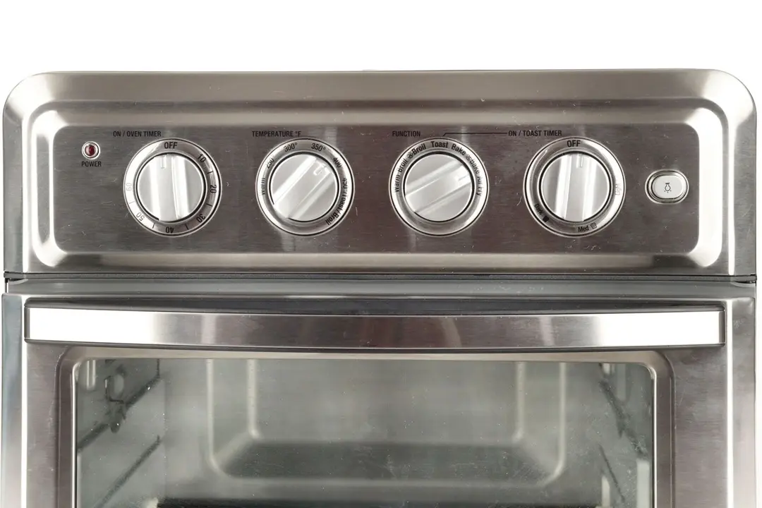 From left to right, the control panel of the stainless steel Cuisinart TOA-60 Convection Toaster Oven Air Fryer has four control dials for on/oven timer, temperature, function, on/toast timer, and a light toggle.