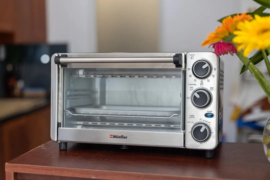 The front of a closed stainless steel Mueller MT-175 4-Slice Countertop Toaster Oven on a white background.