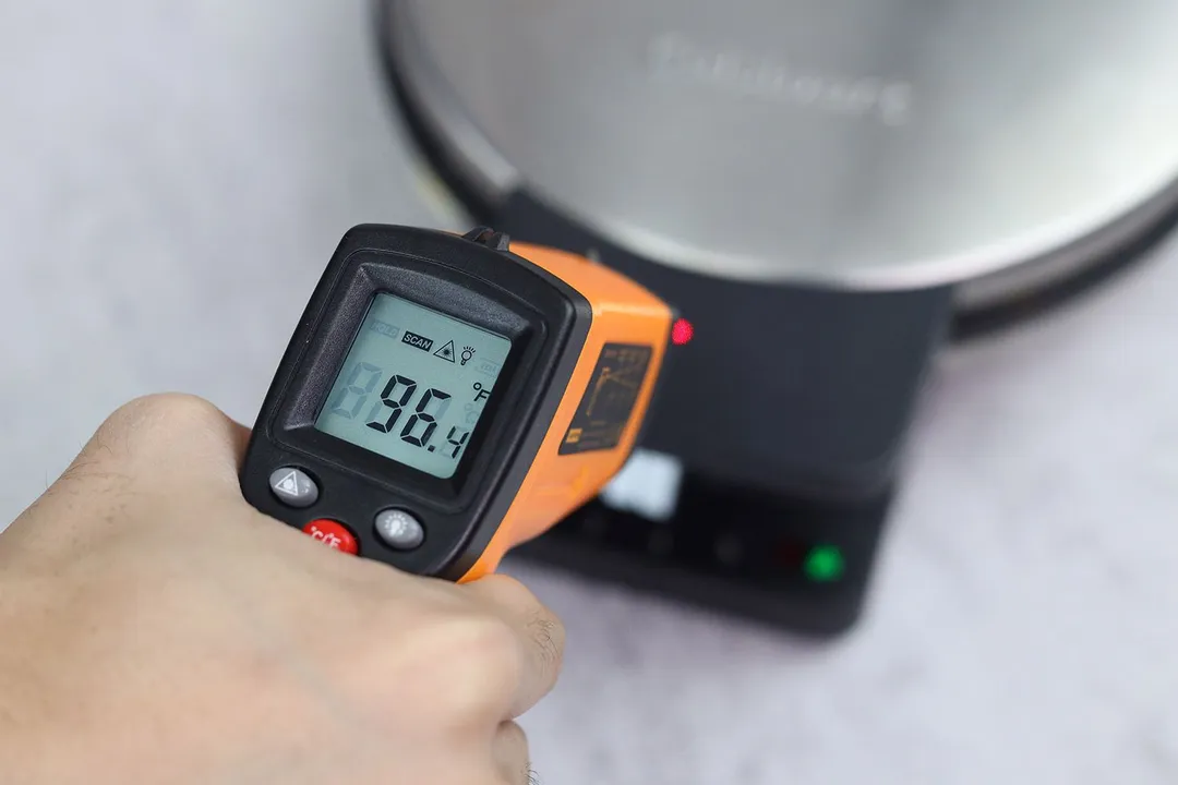 The temperature of the Cuisinart WMR-CA’s cool-touch handle is measured using a thermometer. The screen reads 96.4°F.