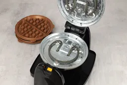 A close-up of the yellow waffle plate release latch on the top handle of the Hamilton Beach waffle maker with removable plates 26031.