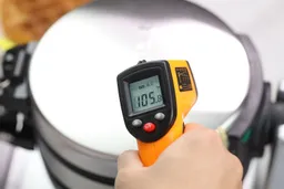 Temperature of the Cuisinart WAF-F20P1’s top lid being measured using a thermometer, which reads 105.8°F during a thermal safety test.