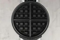A top-down view of the Cuisinart WAF-F20P1 waffle maker’s black, Belgian-style cooking plates.