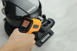 The temperature of the Black and Decker WMD200B’s base is being measured using a thermometer in our thermal safety test. The screen reads 87°F.