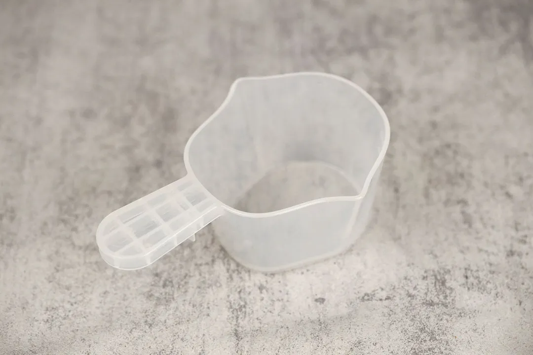 A transparent plastic cup that comes with the Chefman waffle maker. It helps the user measure the batter to pour.