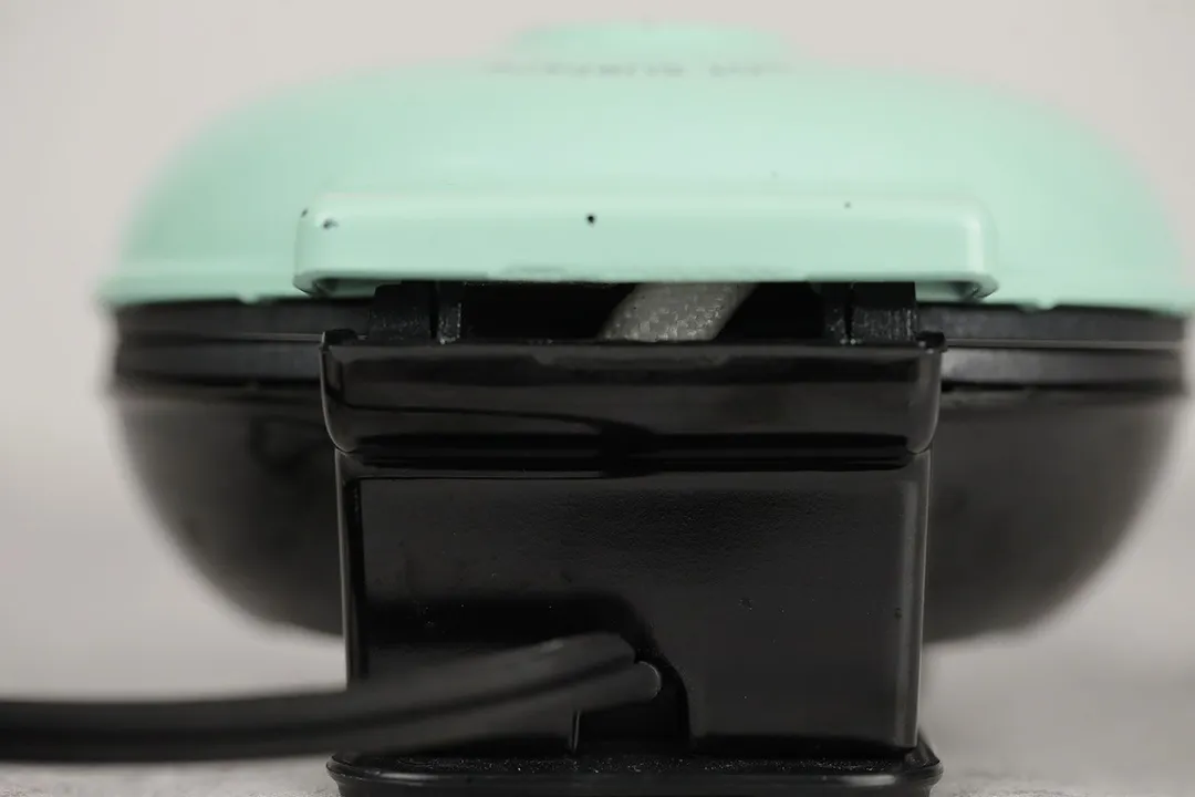 The back side of the DASH Mini waffle maker. White cabling sleeve can be seen through a gap at the back of the unit.
