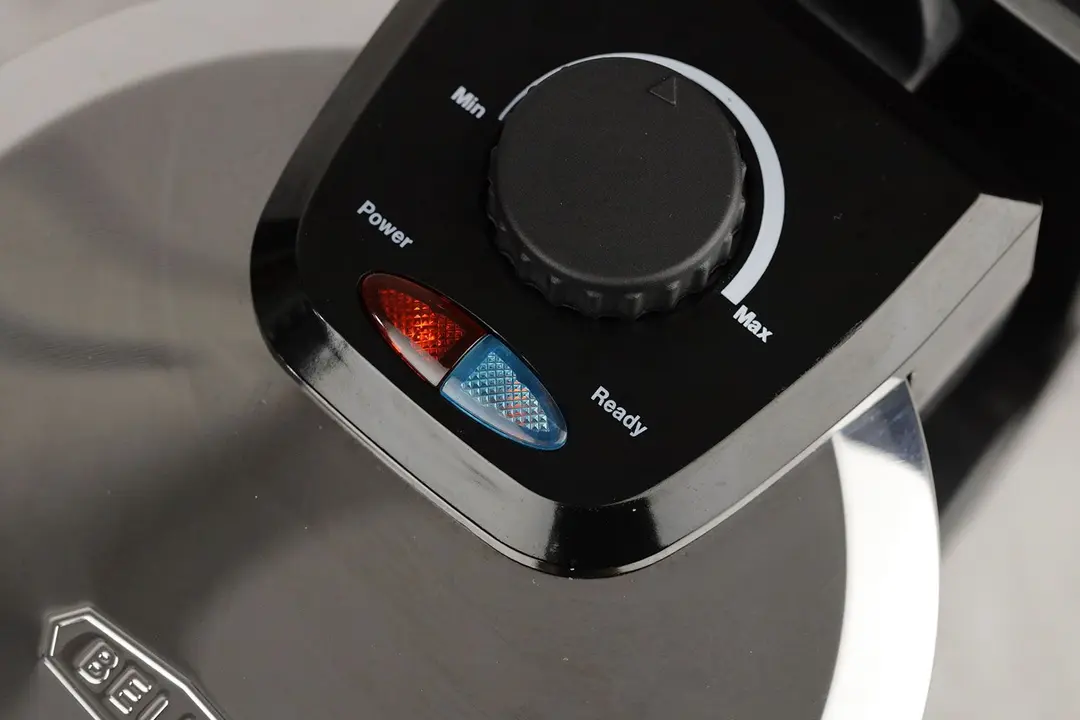 The set of indicator lights at the top of the Bella 13991’s waffle maker. The blue READY light and the red POWER light are on.