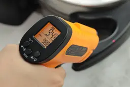 The temperature of the Presto waffle maker’s handle is being measured using a thermometer. The screen reads 94.9°F.