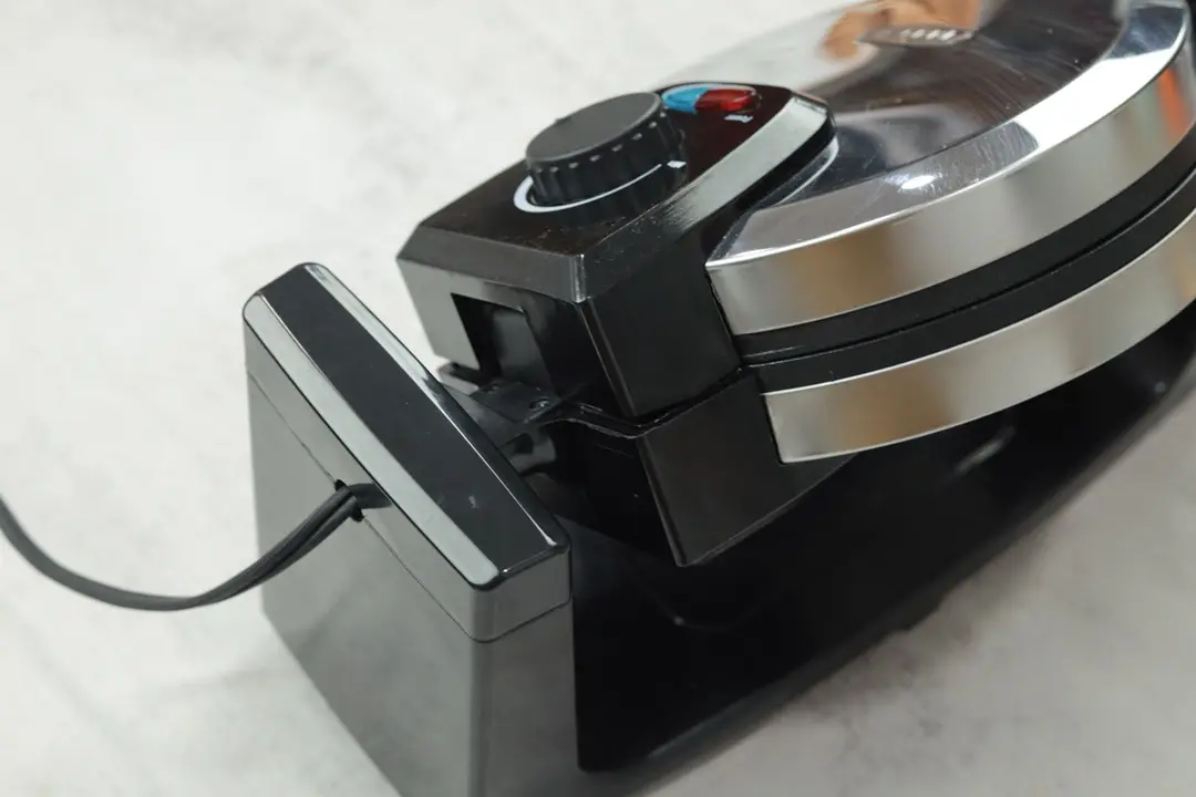 The Bella 13991 rotating waffle maker mid-turn. In the frame is the rotating shaft that allows the baking chamber to rotate.