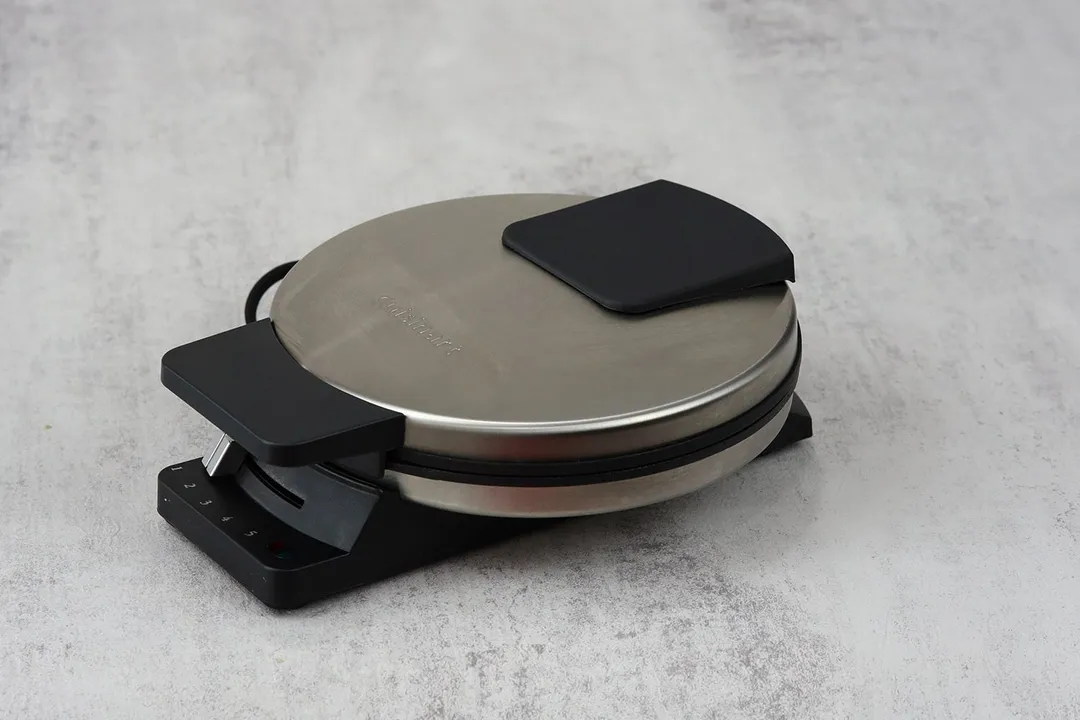 The side profile of a Cuisinart WMR-CA classic waffle maker, showcasing its glossy aluminum body and black plastic detailing.