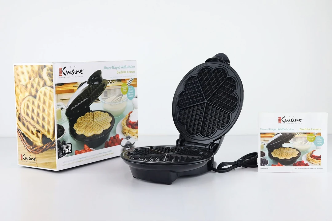 The Euro Cuisine WM520 waffle maker in the center. To its left is its shipping box, and to its right is its manual.