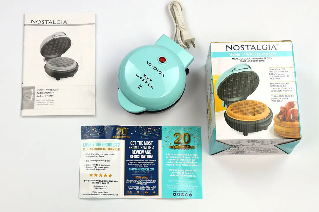 The blue-colored Nostalgia Mini waffle maker MWF5AQ next to its instruction manuals and shipping box.