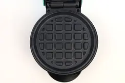 A close-up shot of one of the Nostalgia MWF5AQ’s black, non-stick waffle plates.