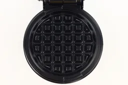 A close-up shot of the Holstein waffle maker’s cooking plate. It is black and treated with a glossy layer of non-stick.