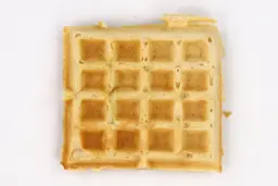 The top crust of a waffle baked for 4 minutes using a batter made from Birch Benders mix. It has a very light gold color.