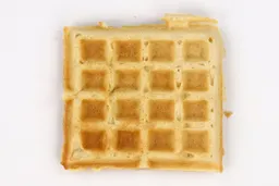 The top crust of a waffle baked for 4 minutes using a batter made from Birch Benders mix. It has a very light gold color.