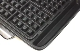 A zoomed-in view of the anti-drip moat on either side of the DASH Deluxe No-Drip Belgian waffle maker.