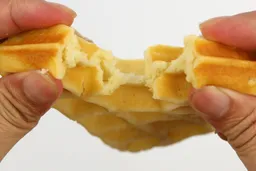 A waffle is torn up by hand to test its consistency. This waffle was baked for 7 minutes using our self-mixed recipe.