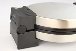 A zoomed-up view of the lid hinges and black plastic housing of the Black and Decker WMB500 waffle maker in its closed state.