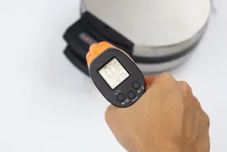 The temperature of the Black and Decker WMB500’s handle is being measured using a thermometer in a thermal safety test. The screen reads 111°F.