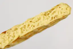 The cross-section of a waffle baked in 5 minutes, revealing the interior filled with air bubbles and air cavities.