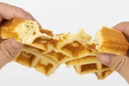 The waffle made by the Hamilton Beach 26031 in 5-minute is torn up by hands to test for consistency and texture.