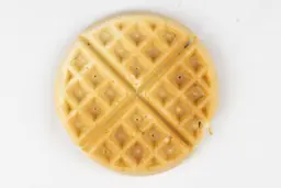 The light gold bottom of a waffle cooked by the Hamilton Beach 26031 waffle maker in 6 minutes using the Birch Benders mix.